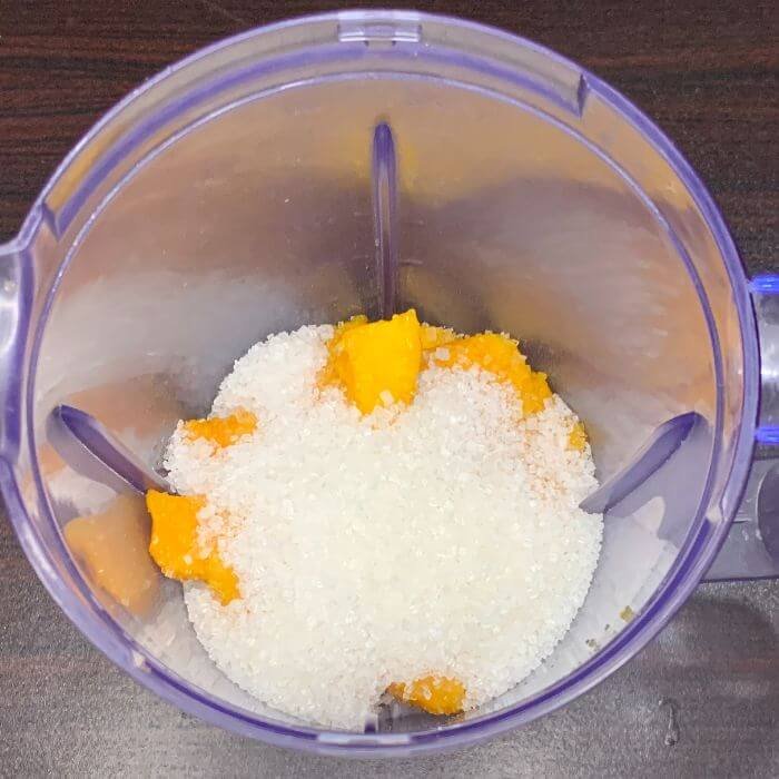 Adding Sugar To a mango lassi blending jug