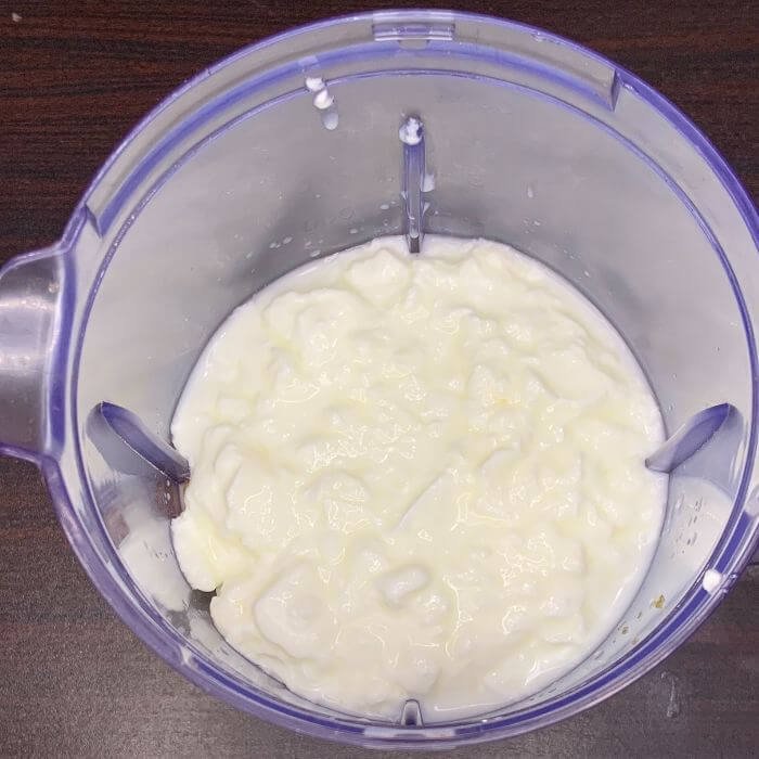 Adding yogurt To a mango lassi blending jug